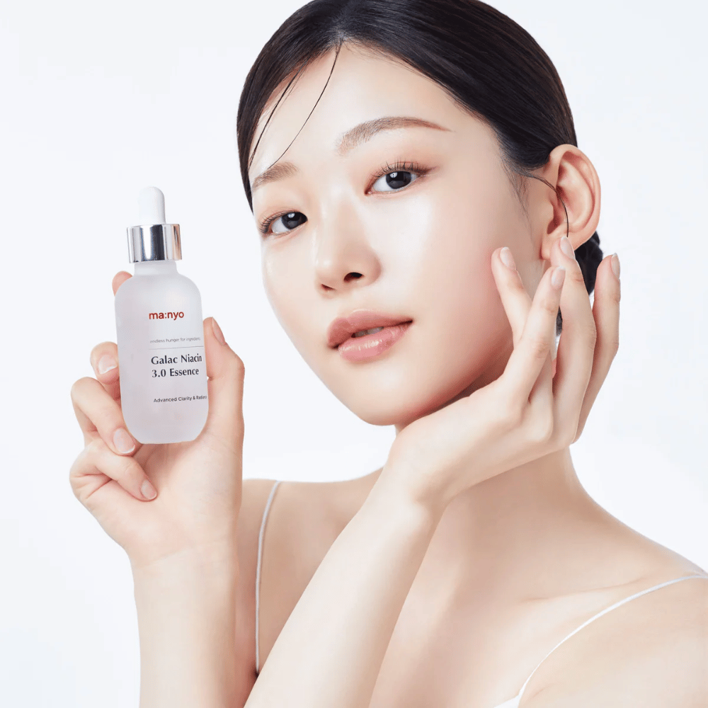 Vrouw met stralende huid houdt Ma:nyo Galac Niacin 3.0 Essence vast – Koreaanse essence die een egalere huidtint en natuurlijke glans geeft.