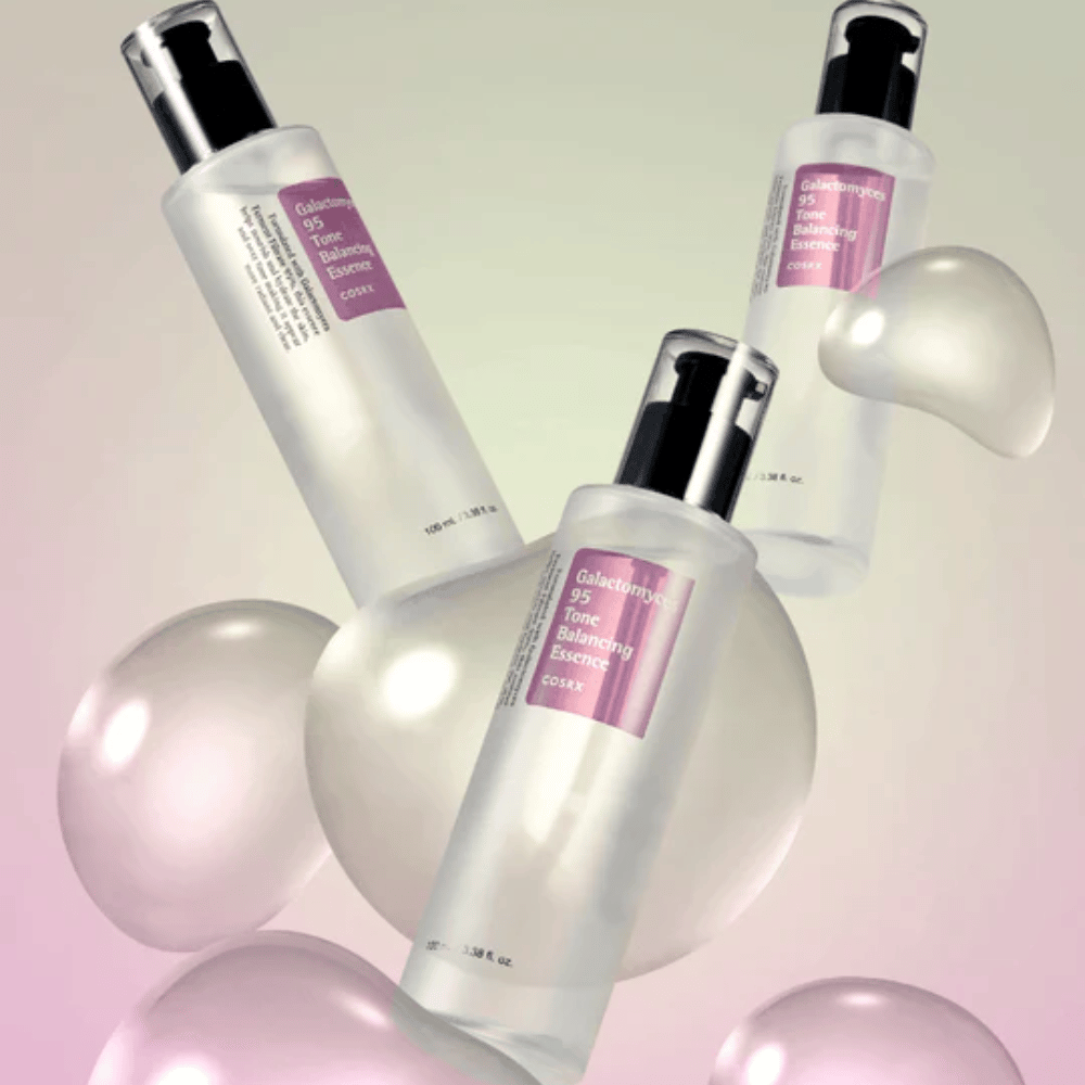 Drie flessen van COSRX Galactomyces 95 Tone Balancing Essence omgeven door lichte bellen. Huidverbeterende essence die de huidtint egaliseert en natuurlijke glans geeft.