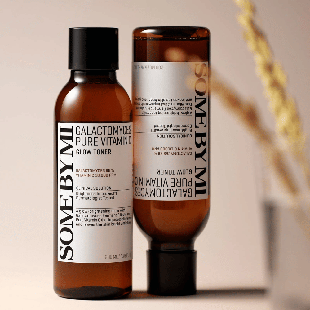 Afbeelding van SOME BY MI Galactomyces Pure Vitamin C Glow Toner. De flessen hebben een strak ontwerp met bruine tinten en een zwarte dop. Het product bevat 88% galactomyces en 10.000 ppm vitamine C, wat belooft de huidglans te verbeteren en een frissere huidtint te geven.