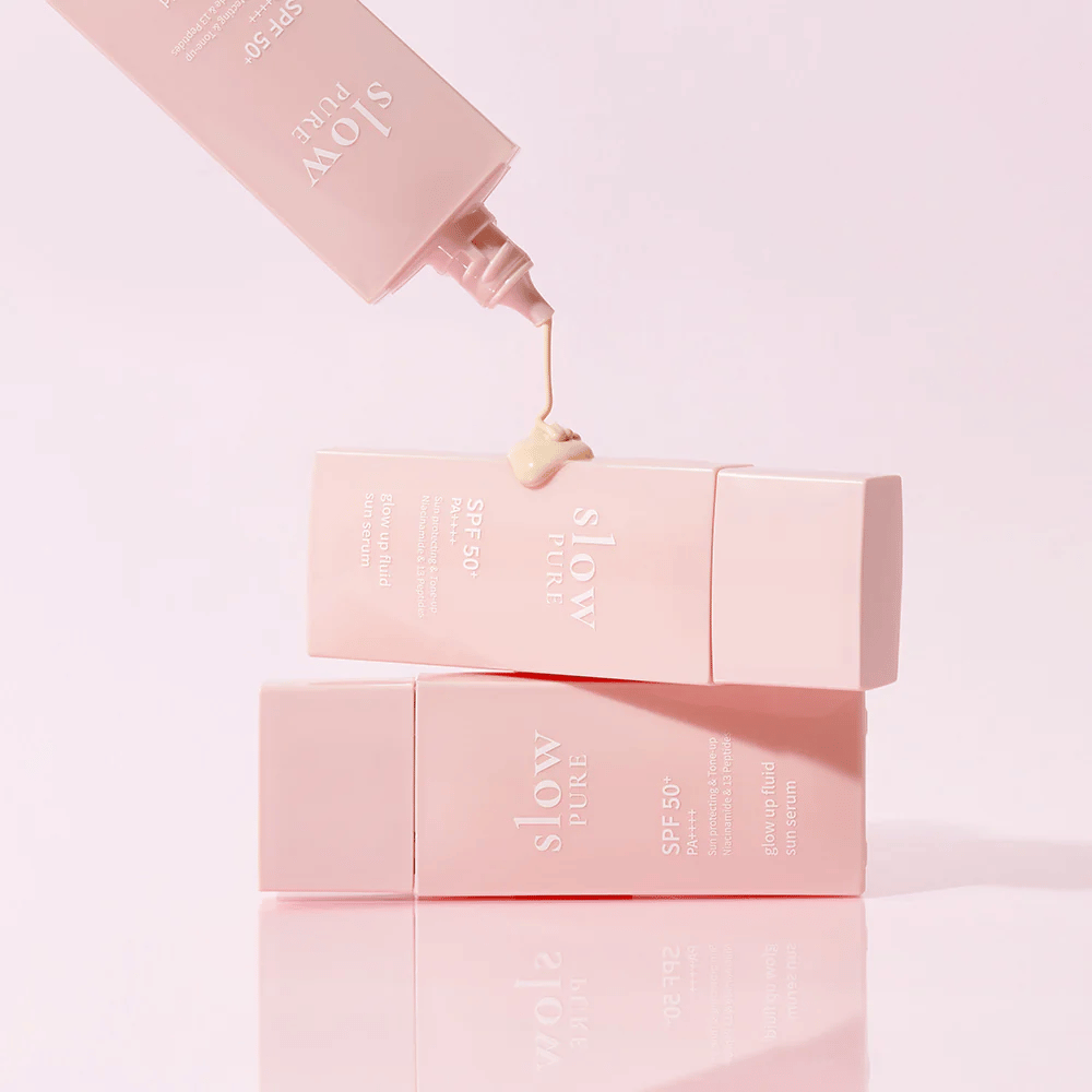 Slow Pure Glow Up Fluid Sun Serum met crème uit de fles geperst, toont lichte en verzorgende textuur.