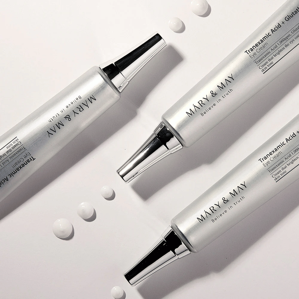 Gestylede productfoto van Mary&May Tranexamic Acid + Glutathione Eye Cream die de consistentie van de crème en de focus op oplichtende oogverzorging toont.