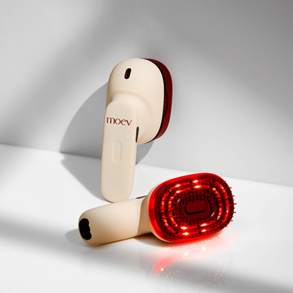 Twee MOEV Hair Steamer Pro op witte achtergrond. Eén toont geactiveerde rode LED-lampen die de hoofdhuid stimuleren en de haargroei verbeteren.