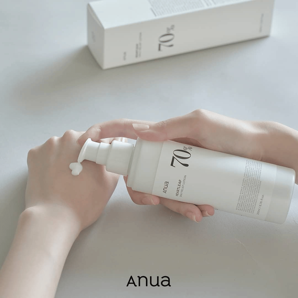 Een persoon houdt een fles Anua Heartleaf 70% Daily Lotion 200ml vast.