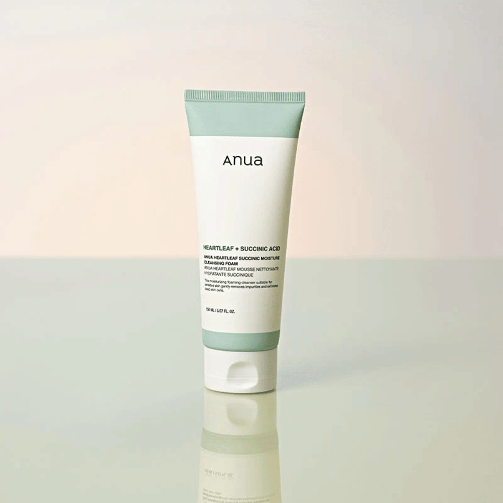 Vrijstaande productafbeelding van Anua Heartleaf + Succinic Acid Moisture Cleansing Foam. Het product wordt staand getoond op een reflecterend oppervlak dat het ontwerp van de verpakking en de strakke esthetiek van het merk duidelijk benadrukt.