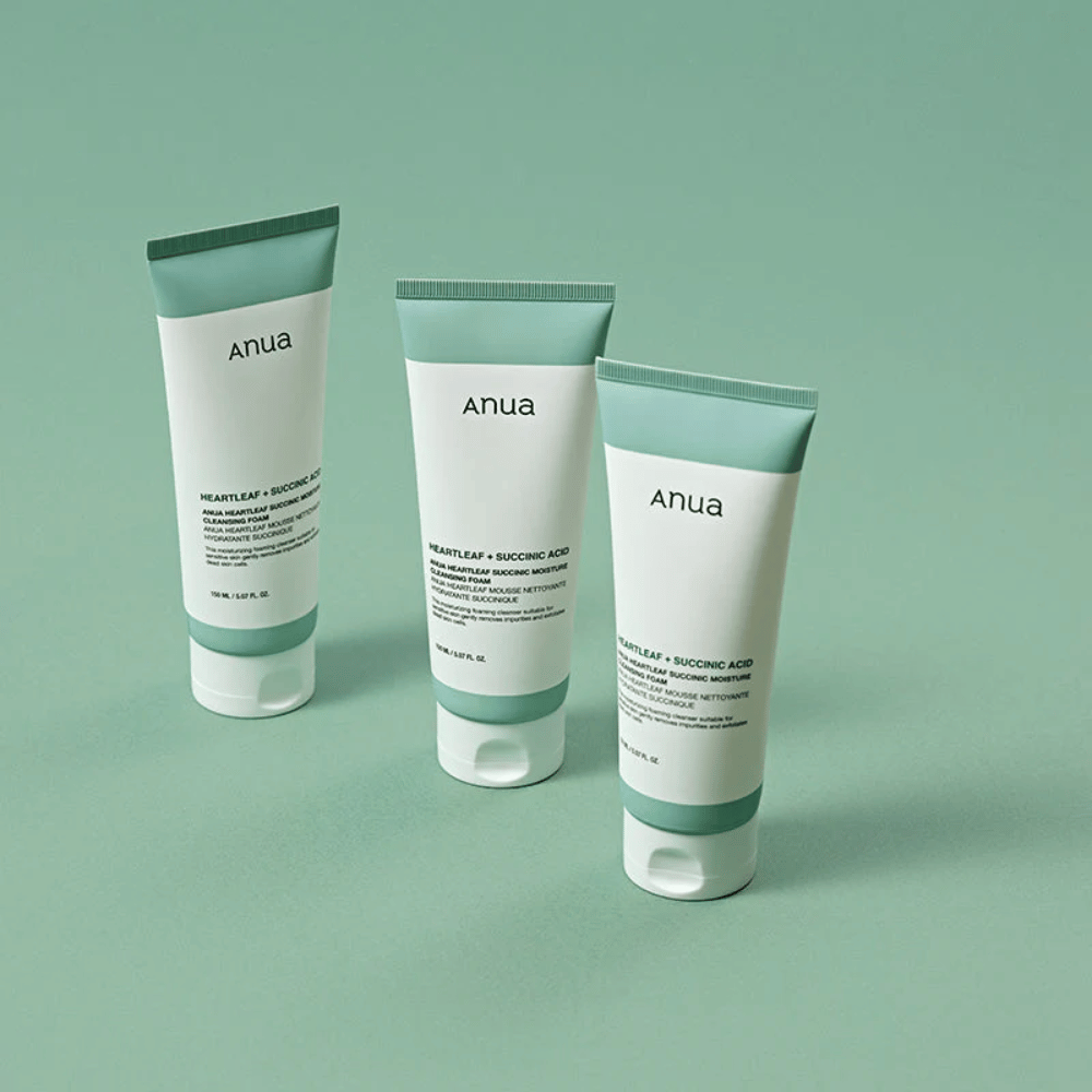 Drie verpakkingen van Anua Heartleaf + Succinic Acid Moisture Cleansing Foam gepresenteerd tegen een lichtgroene achtergrond. De afbeelding benadrukt het schone en minimalistische ontwerp van het product en geeft een professionele indruk van de productlijn.