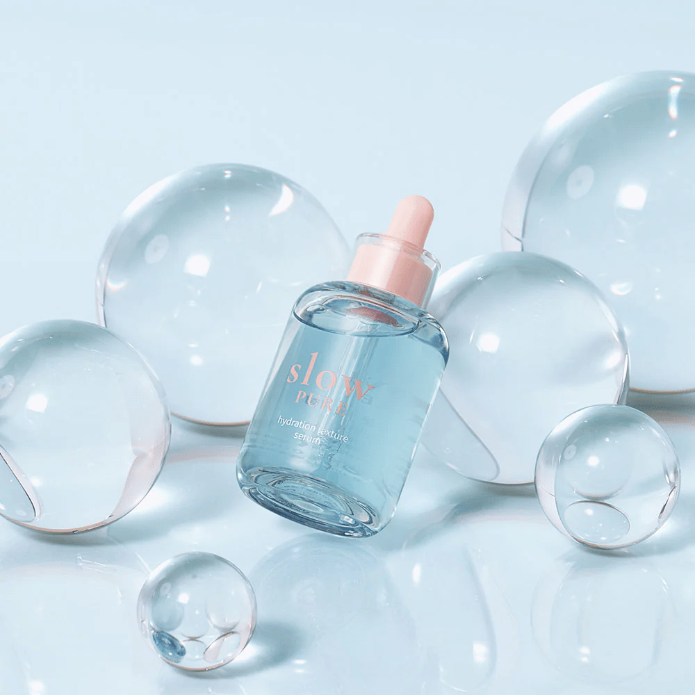 Slow Pure Hydration Texture Serum geplaatst tussen doorzichtige bellen, symbool voor intensieve hydratatie.