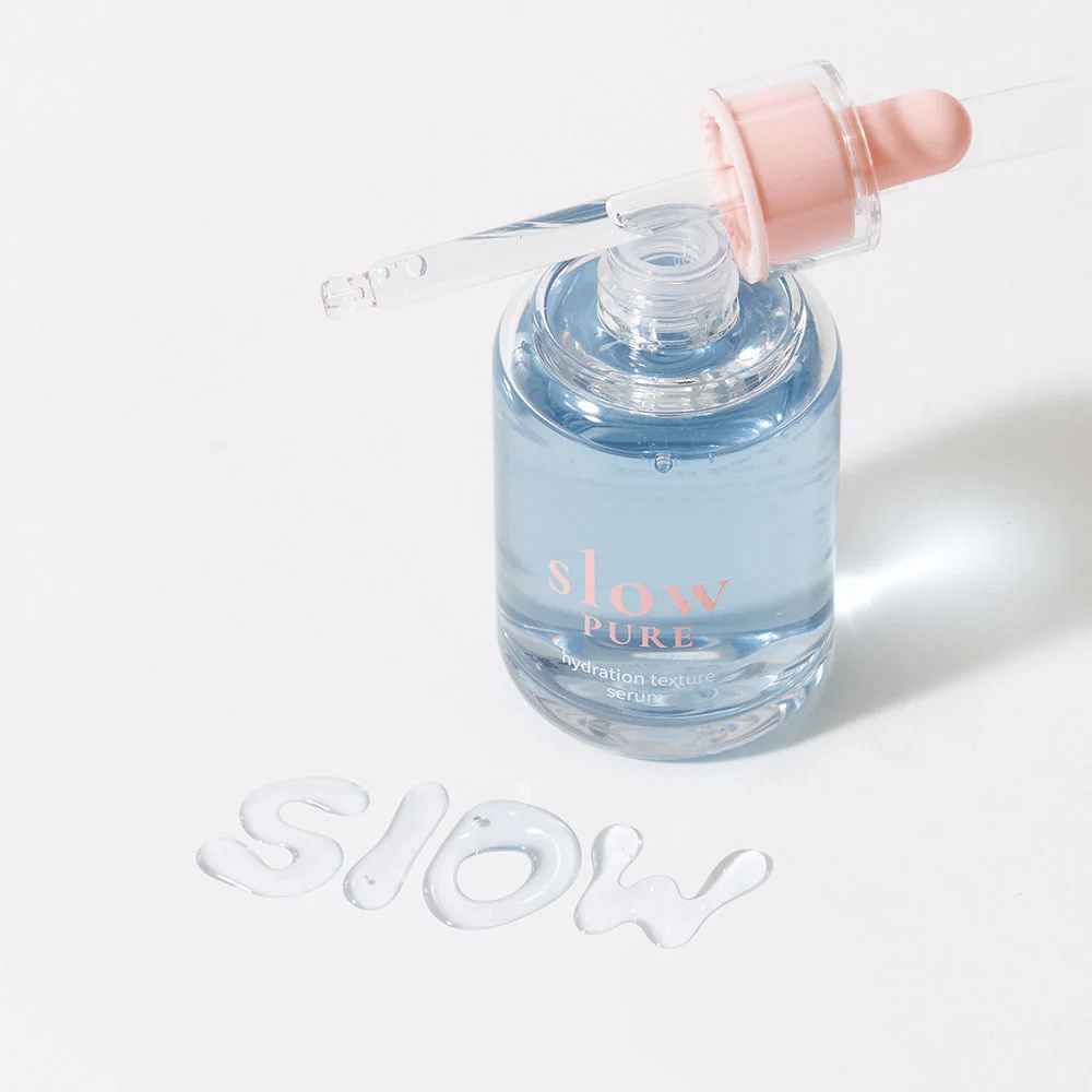 Slow Pure Hydration Texture Serum met open pipet, tekst geschreven in serum op het oppervlak: "Slow".