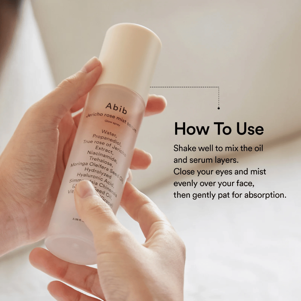 Persoon houdt Abib Jericho Rose Mist Serum vast en toont hoe je de fles schudt om olie en serum te mengen voor gebruik.