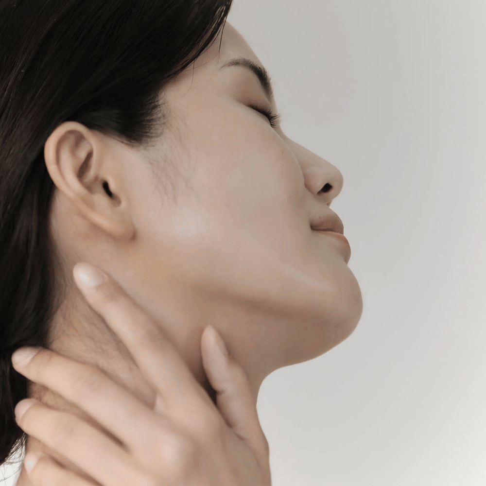 Kvinna visar sin lugna, återfuktade hud efter användning av Celimax Ji Woo Gae Cica BHA Blemish Toner Pad.