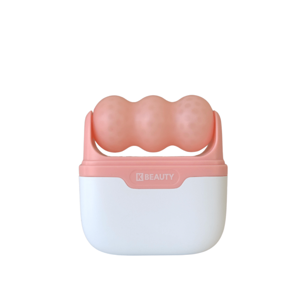 De afbeelding toont een K-Beauty Ice Roller met een wit en roze handvat. Het product heeft drie afgeronde, gestippelde rollen in roze kleur aan de bovenkant, ontworpen om het gezicht te koelen en te masseren. De achtergrond is geheel wit.