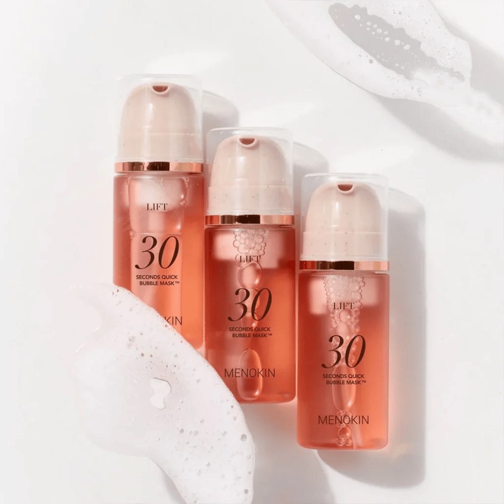 Esthetische productafbeelding met drie flessen van MENOKIN LIFT 30 Seconds Quick Bubble Mask omringd door zacht schuim dat het bruisende en reinigende effect benadrukt.