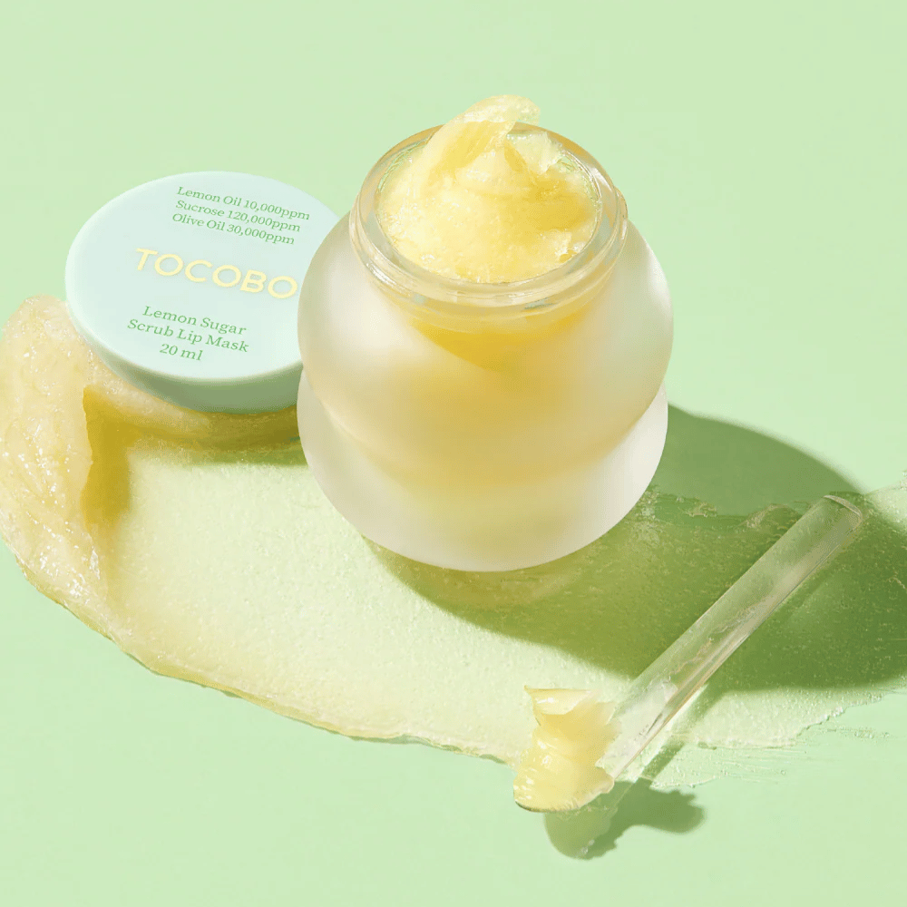 Open pot met Tocobo Lemon Sugar Scrub Lip Mask op een groene achtergrond, met de inhoud duidelijk zichtbaar.