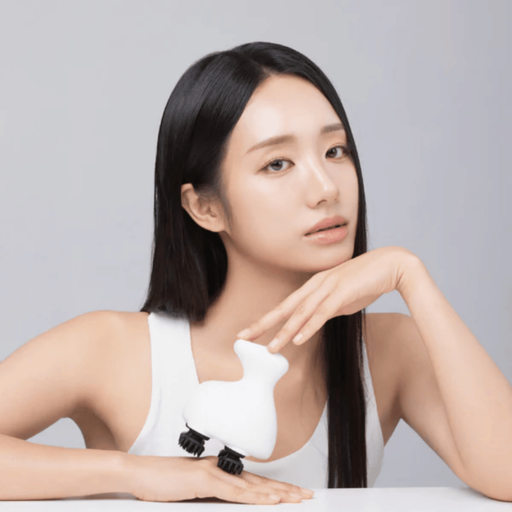Model poseert met Beaund Lift Head Spa en toont het ergonomische ontwerp. De afbeelding benadrukt het product als een hulpmiddel voor hoofdhuidmassage en ontspannende zelfverzorging.