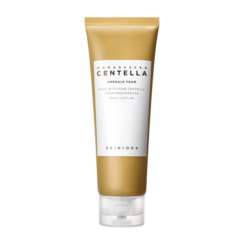 De afbeelding toont een tube van "Madagascar Centella Ampoule Foam" van het merk SKIN1004. Het is een reinigingsproduct voor het gezicht dat 125 ml / 4.22 fl.oz bevat. De formule is gebaseerd op pure Centella, geëxtraheerd uit planten in Madagaskar. Het product is ontworpen om de huid zachtjes te reinigen en te verzorgen.