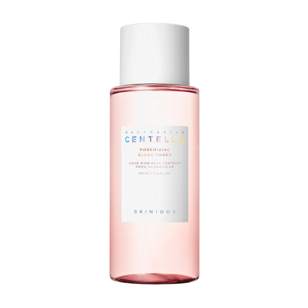 Een fles met Madagascar Centella Poremizing Clear Toner, die transparant is met een roze tint. Het product heeft een witte dop en etiket met de tekst "Poremizing Clear Toner" en "Made with Pure Centella from Madagascar." De fles bevat 210 ml en geeft een gevoel van frisheid en huidverzorging.