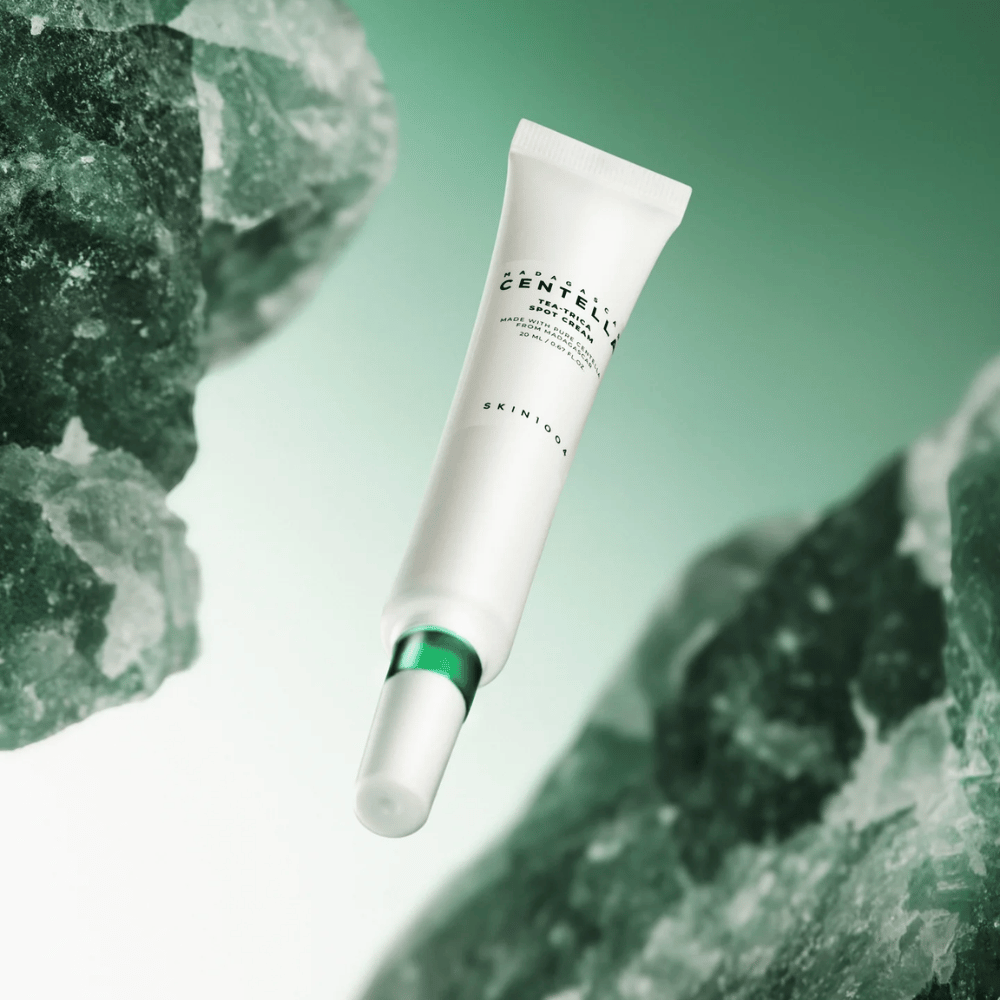 SKIN1004 Madagascar Centella Tea-Trica Spot Cream 20 ml tegen acne en puistjes, productafbeelding met groene achtergrond en kristalstructuur – kalmerende spotbehandeling met centella asiatica en tea tree.
