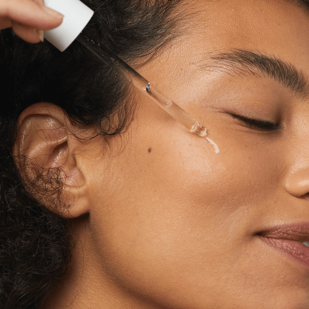 Vrouw brengt Skin1004 Madagascar Centella Hyalu-Cica First Ampoule aan op haar wang met een pipet.