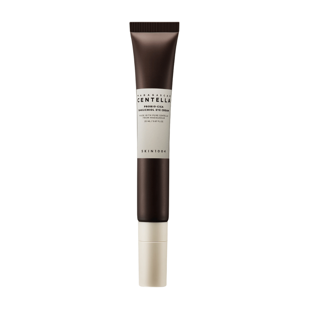 Een tube van "Madagascar Centella Probio-Cica Bakuchiol Eye Cream" van SKIN1004. Het product is ontworpen voor het gebied rond de ogen en bevat ingrediënten zoals centella uit Madagaskar en bakuchiol, bekend om hun huidverzorgende en hydraterende eigenschappen. De tube is stijlvol met een donkerbruine kleur die overgaat in wit.