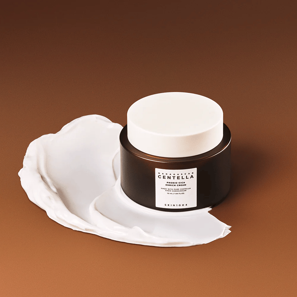 SKIN1004 Madagascar Centella Probio-Cica Enrich Cream geplaatst op een laag crème – hydraterende en kalmerende gezichtscrème met centella asiatica.