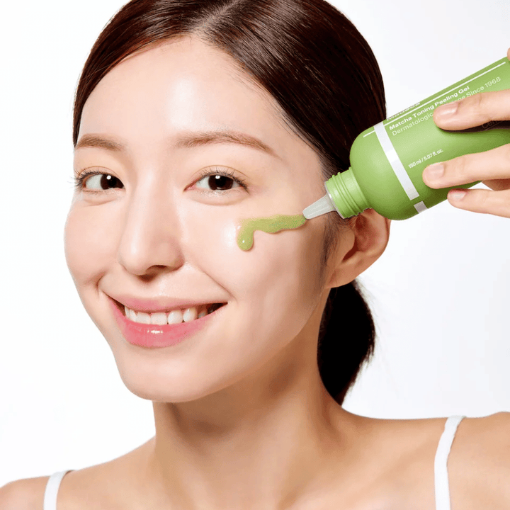 Persoon die Centellian24 Madeca Matcha Toning Peeling Gel aanbrengt – milde peeling die helpt dode huidcellen te verwijderen en de huid zachter en stralender te maken.