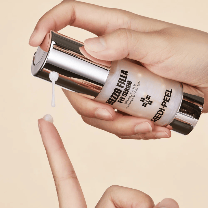 Toepassing van MEDI-PEEL Mezzo Filla Eye Serum op vingertop – licht oogserum dat snel wordt geabsorbeerd en intense hydratatie en anti-aging effect biedt.