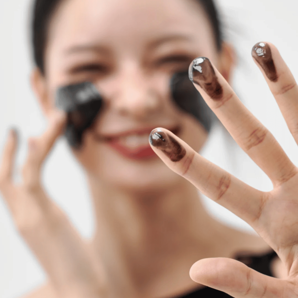 Model brengt Hoe Midnight Soothing Cleansing Balm aan op de huid. Romige reinigingsbalsem die diep reinigt en de huid zacht en in balans achterlaat.