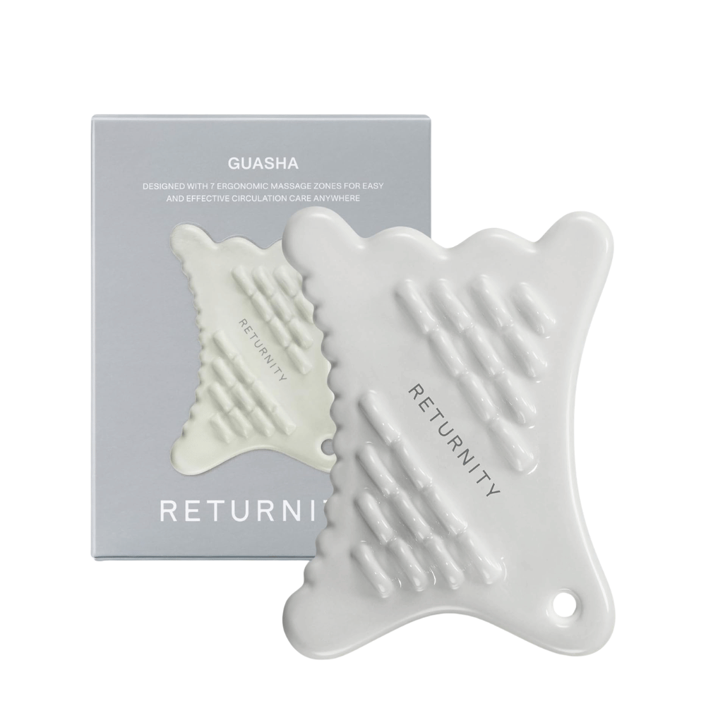 RETURNITY gua sha-verktyg i vit ergonomisk design tillsammans med produktförpackning, utvecklat för ansikts- och kroppsmassage med flera strukturerade massagezoner.