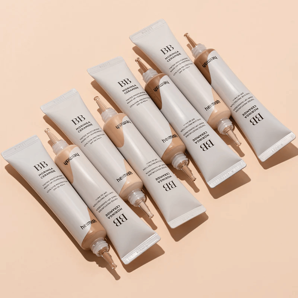 Meerdere tubes van Heimish Moringa Ceramide BB Cream gerangschikt op een lichtbeige achtergrond. De afbeelding benadrukt de verschillende tinten en het elegante, minimalistische verpakkingsontwerp van het product.