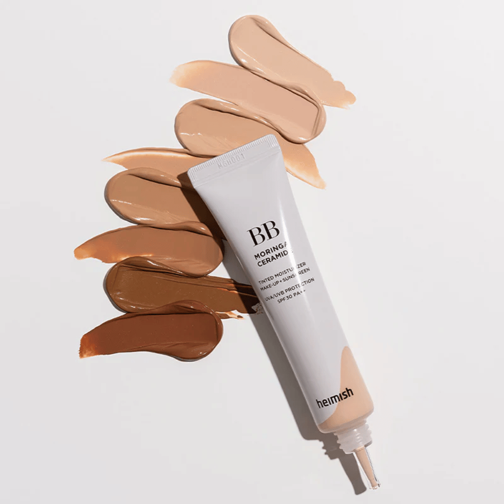 Heimish Moringa Ceramide BB Cream omgeven door meerdere kleurstalen in verschillende huidtinten. De afbeelding toont het brede kleurassortiment van het product en de romige textuur die zorgt voor een natuurlijke dekking en een egale huidtoon.