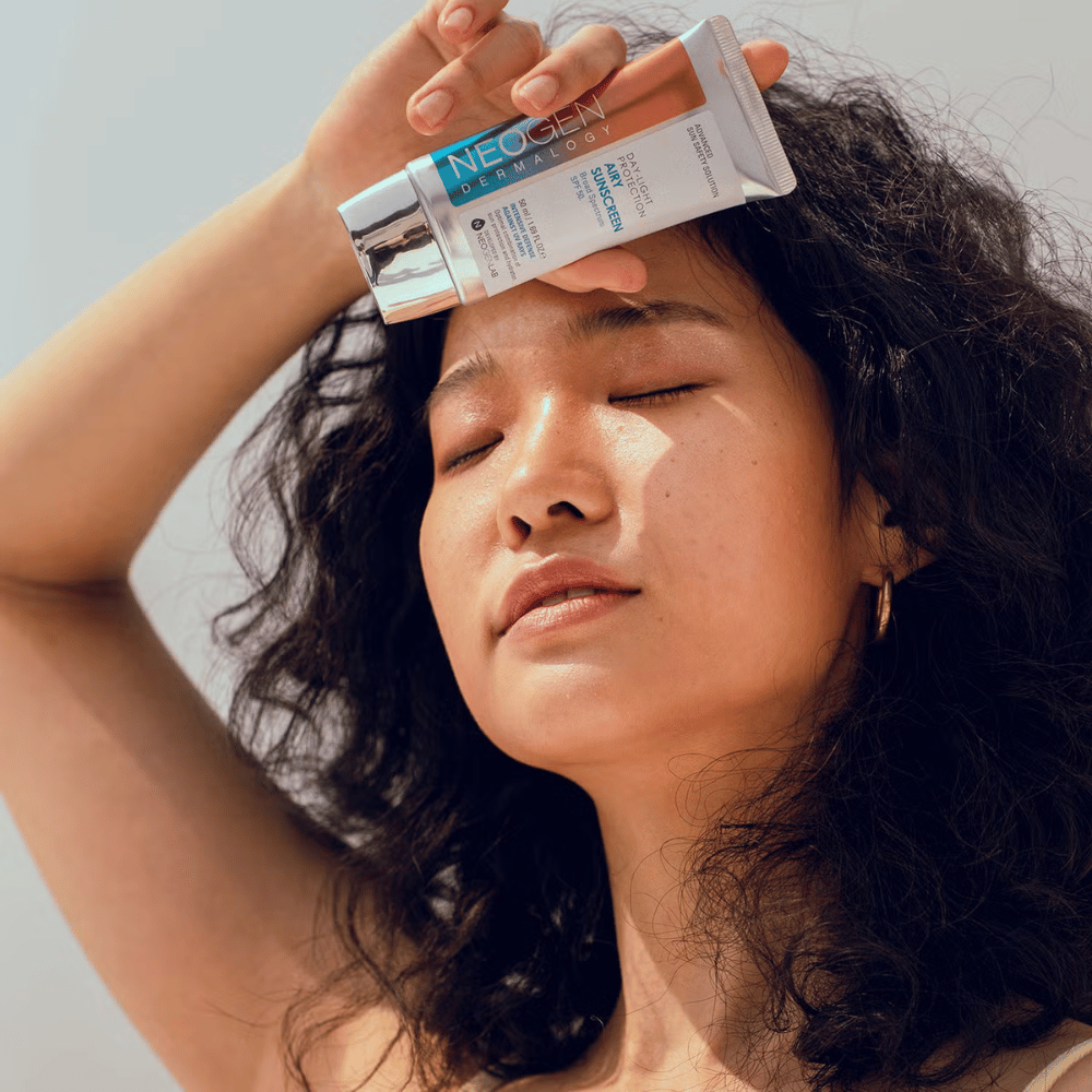 Neogen Dermalogy Day-Light Protection Airy Sunscreen SPF50 50ml – lichte zonnebrandcrème met breedspectrum UV-bescherming, getoond in gebruik in zonlicht.