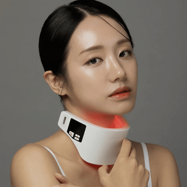 Model gebruikt Beaund Neckcera rond de hals. De rode LED-verlichting illustreert de actieve behandeling terwijl het apparaat comfortabel tegen de huid zit.
