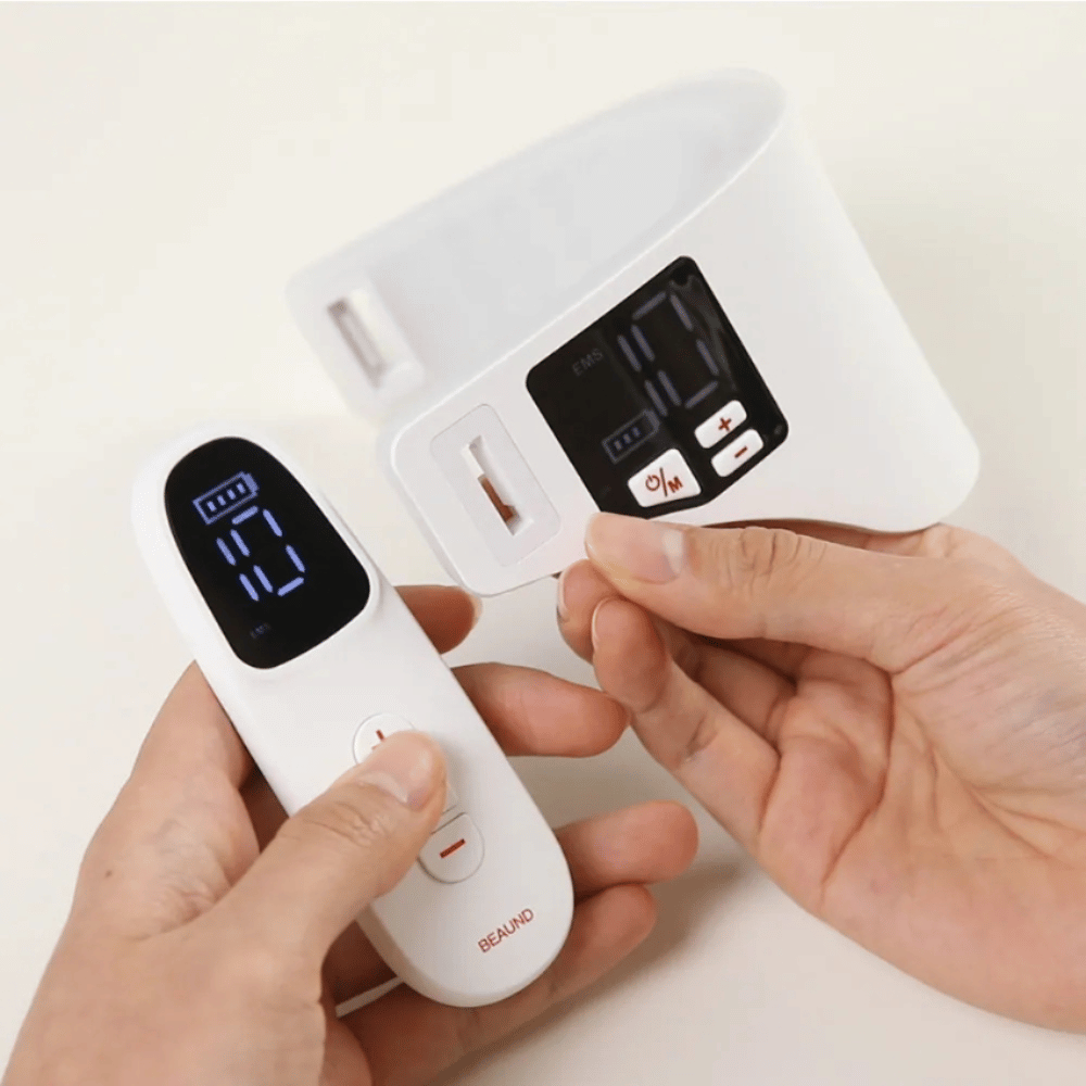 Beaund Neckcera wordt getoond samen met de meegeleverde afstandsbediening. De afbeelding demonstreert de draadloze bediening en het digitale display waarop intensiteit en functies kunnen worden aangepast.
