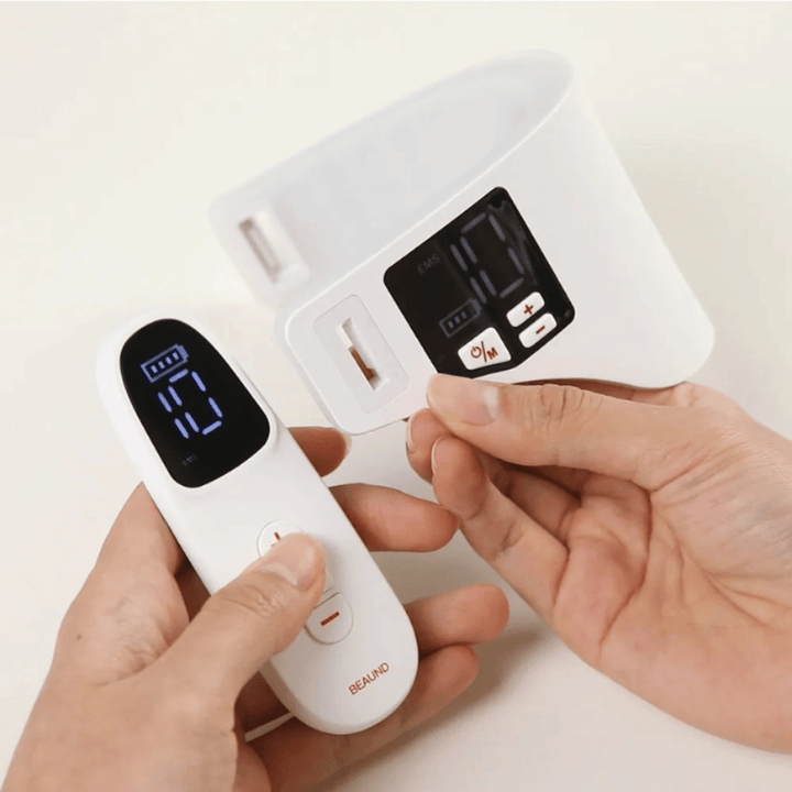 Beaund Neckcera wordt getoond samen met de meegeleverde afstandsbediening. De afbeelding demonstreert de draadloze bediening en het digitale display waarop intensiteit en functies kunnen worden aangepast.