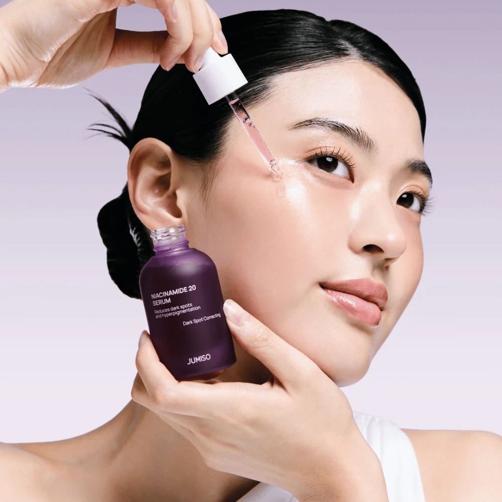 Kvinna applicerar Jumiso Niacinamide 20 Serum – lystergivande koreanskt serum som jämnar ut hudtonen och minskar pigmentfläckar.