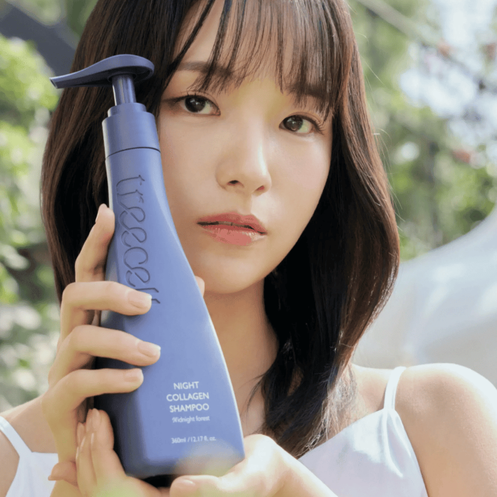 Vrouw houdt Treecell Night Collagen Shampoo Midnight Forest omhoog in een natuurlijke omgeving. De afbeelding straalt gezond haar, glans en een premiumgevoel uit met focus op haar- en hoofdhuidverzorging.