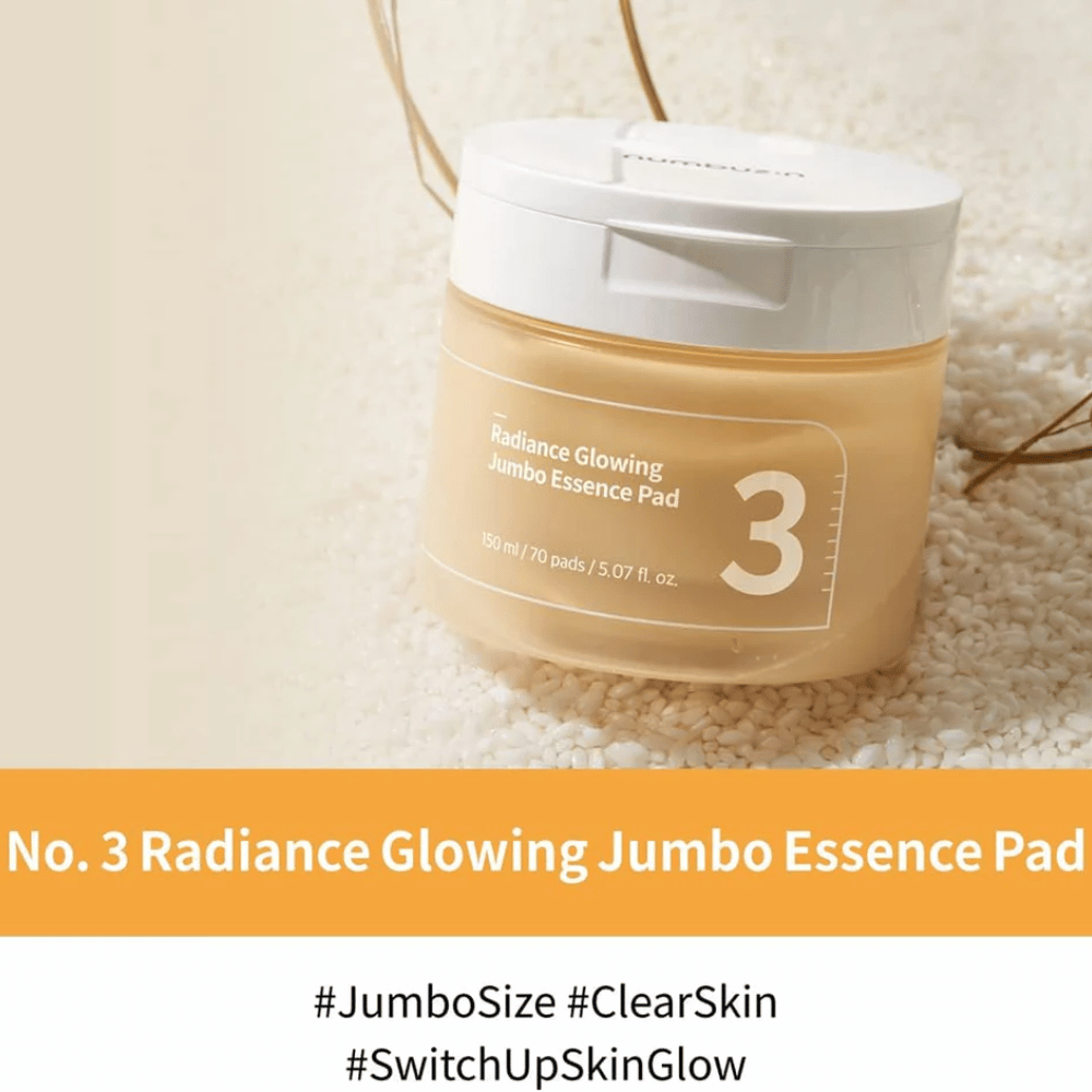 Pot met numbuzin No. 3 Radiance Glowing Jumbo Essence Pad geplaatst op rijst, tekst op de afbeelding benadrukt jumbo-formaat en de glow van de huid.