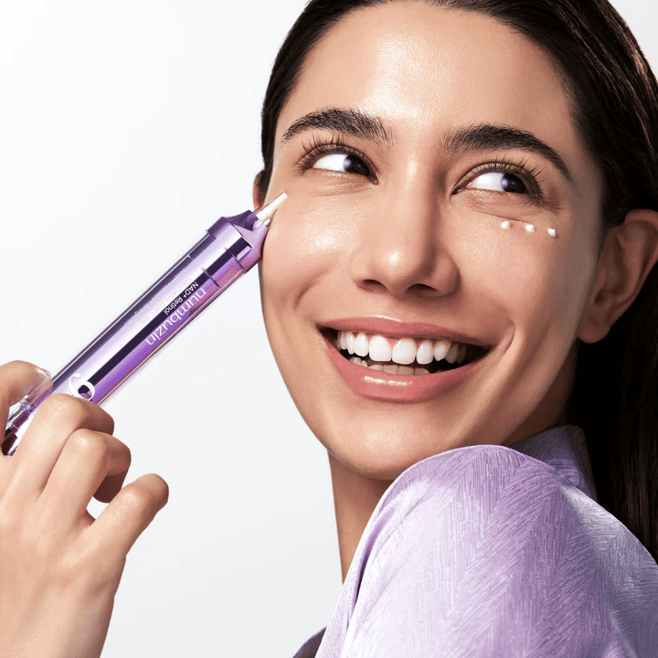 Model die No.9 NAD+ Retinol Volumetox Eye Cream aanbrengt rond de ogen met precisieapplicator, voor gerichte verzorging van donkere kringen en fijne lijntjes.