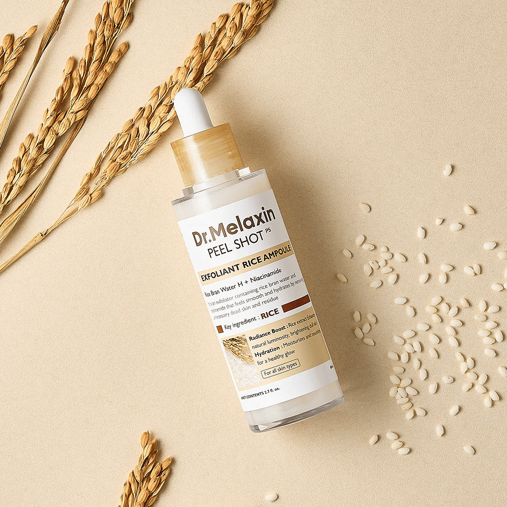 Dr.Melaxin Peel Shot Rice Ampoule liggend op zandkleurig oppervlak met rijst en aren, exfoliërende gezichtsampul die milde peeling combineert met intense hydratatie.