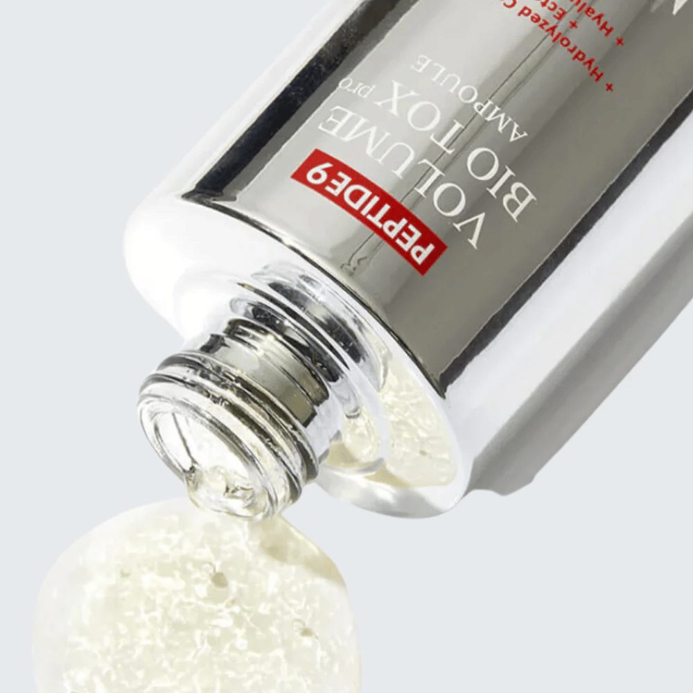Close-up van MEDI-PEEL Peptide 9 Volume Bio Tox Pro Ampoule die wordt uitgegoten. De heldere formule met collageen, ectoine en hyaluronzuur hydrateert diep.