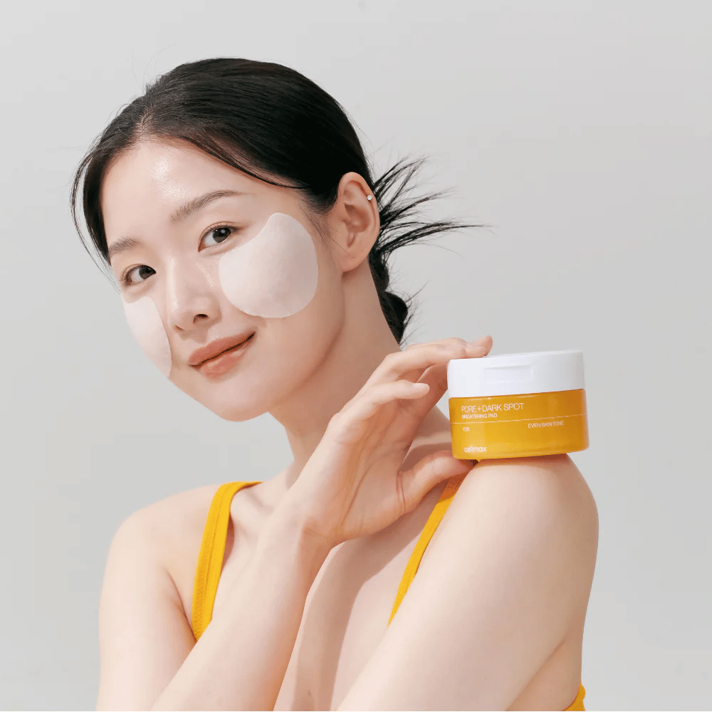 Vrouw brengt Celimax Pore + Dark Spot Brightening Pad aan – Koreaanse pads die de huidteint egaliseren en poriën en pigmentvlekken verminderen.