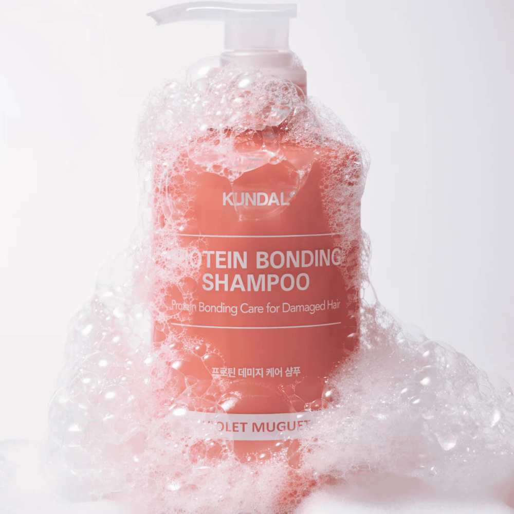 KUNDAL Protein Bonding Shampoo Violet Muguet bedekt met rijkelijk schuim, herstellende shampoo voor beschadigd haar.
