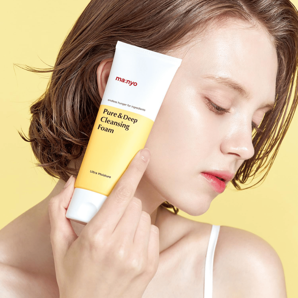 Kvinna med frisk, återfuktad hud håller Ma:nyo Pure & Deep Cleansing Foam – mild ansiktsrengöring som ger lyster och balans med naturliga ingredienser.