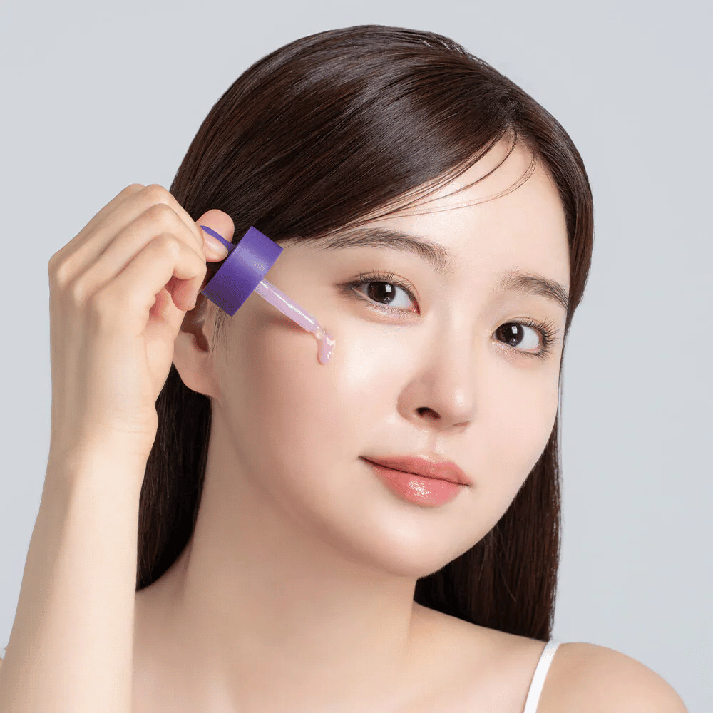 Aanbrengen van Cellology Purple Carrot Pore Ampoule met pipet op het gezicht voor porieverzorging en een egalere huidtextuur.