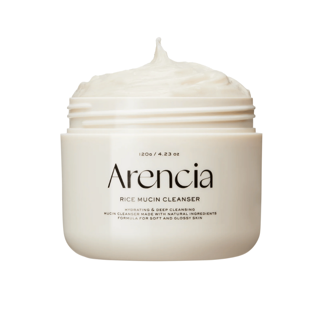 Productafbeelding van Arencia Rice Mucin Cleanser in een witte pot met een romige, opgeklopte textuur die uit de opening steekt. De tekst op de verpakking benadrukt hydratatie en diepe reiniging.