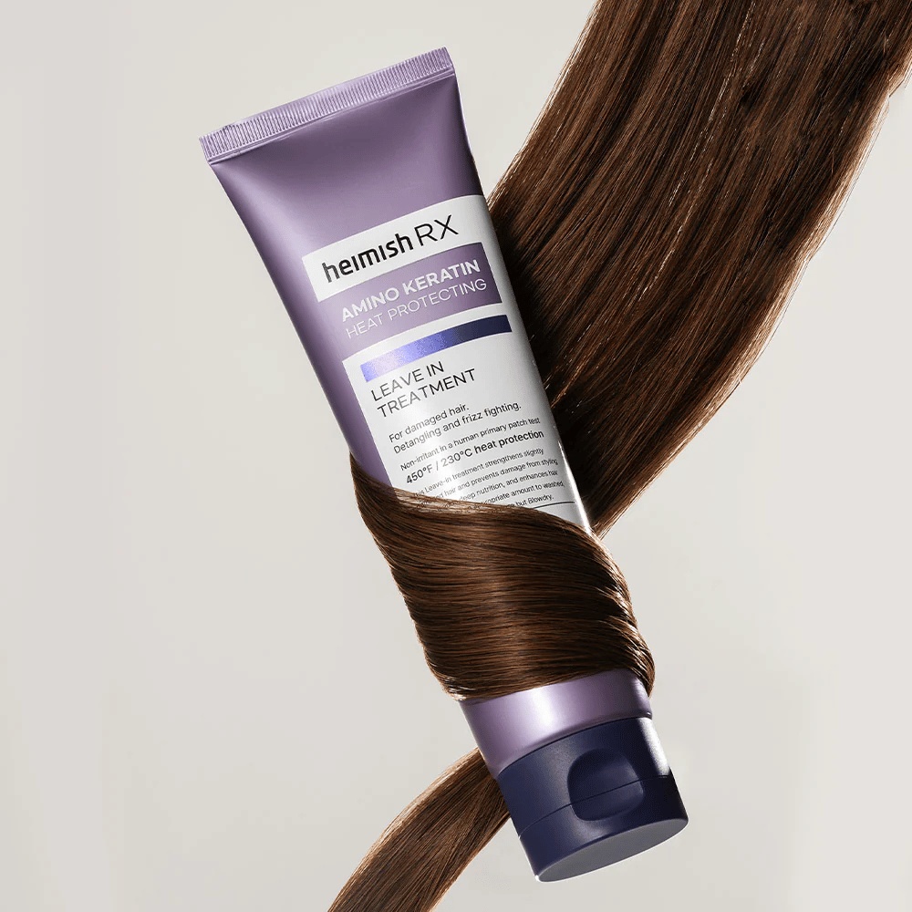 Heimish RX Amino Keratin Leave-In Treatment - voedende hittebeschermende haarbehandeling omgeven door glanzend haar, symboliseert versterkende en hydraterende werking voor beschadigd haar.