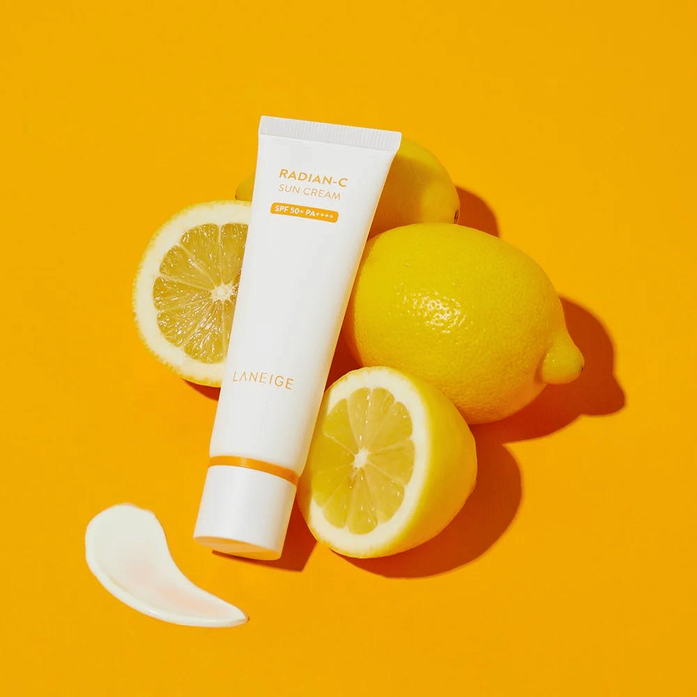 LANEIGE Radian-C Sun Cream SPF 50+ PA++++ met citroenen en een klodder zonnebrandcrème op een kleurrijke gele achtergrond.
