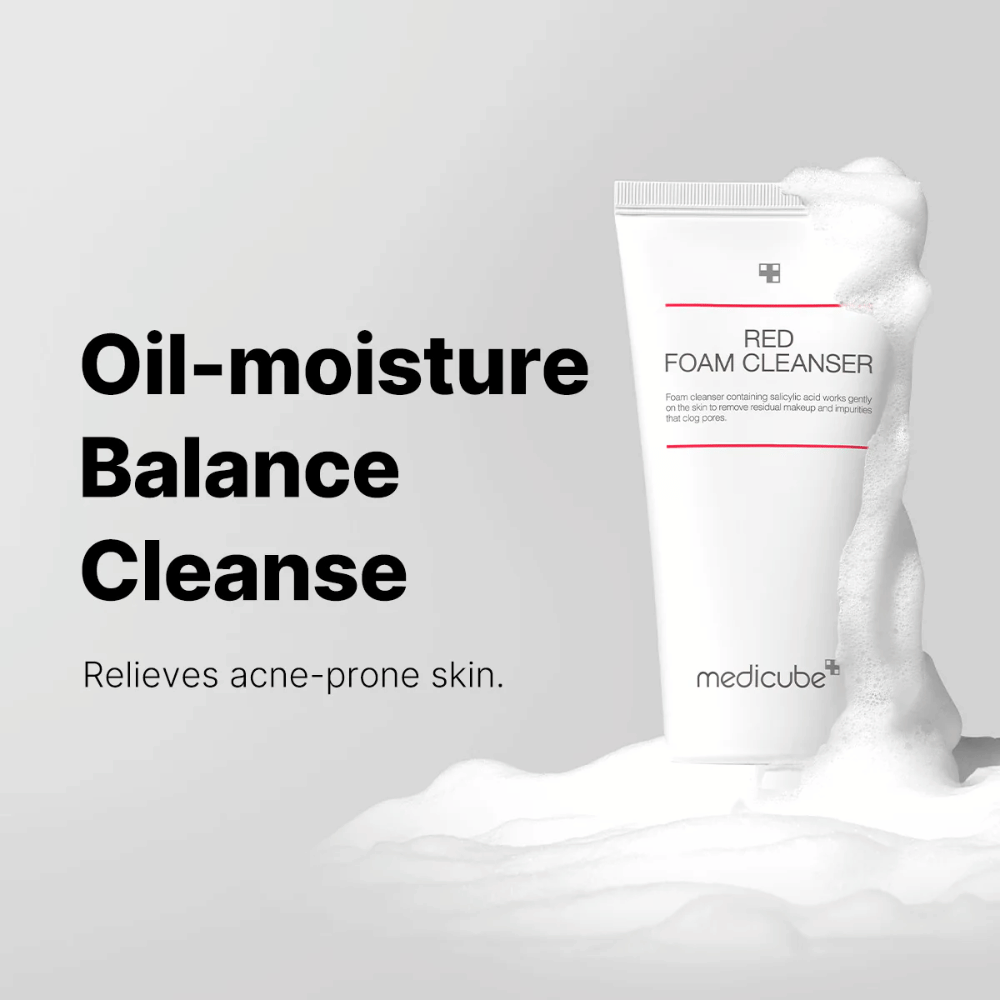 Tub med Medicube Red Foam Cleanser står upprätt bland löddrande skum. Texten "Oil-moisture Balance Cleanse" visas till vänster, med beskrivningen "Relieves acne-prone skin" under. Bakgrunden är ljusgrå.