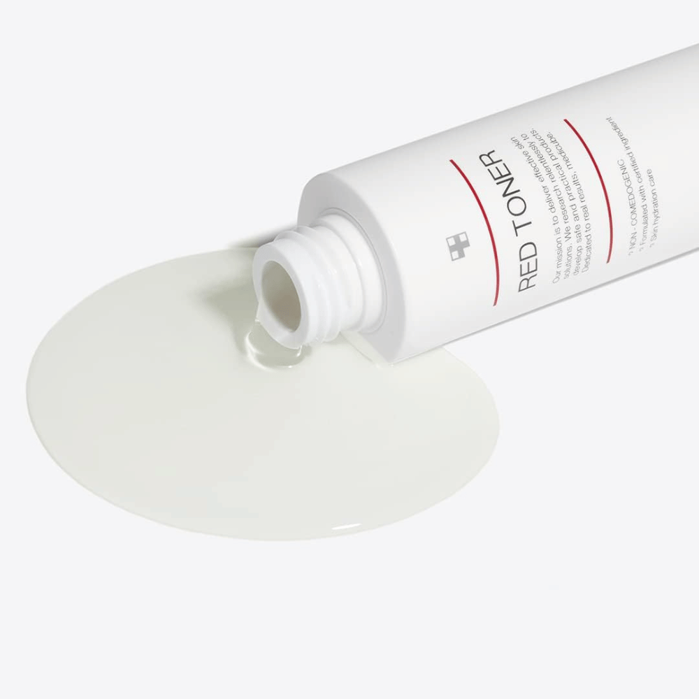 Open fles met medicube Red Toner die op een wit oppervlak wordt gegoten – toont de lichte en vloeibare consistentie van het product.