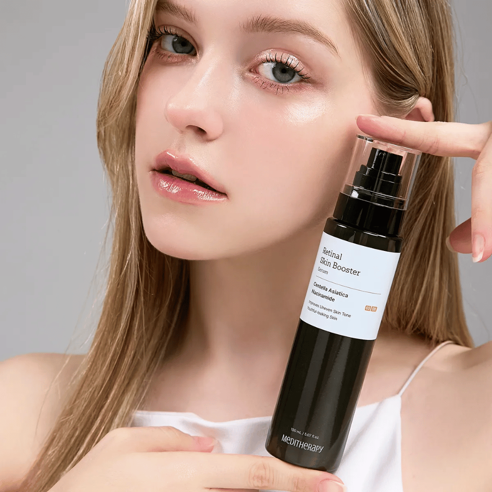 Persoon houdt Meditherapy Retinal Skin Booster Serum omhoog. De huid ziet er egaal, gehydrateerd en stralend uit - het resultaat van retinal en niacinamide.