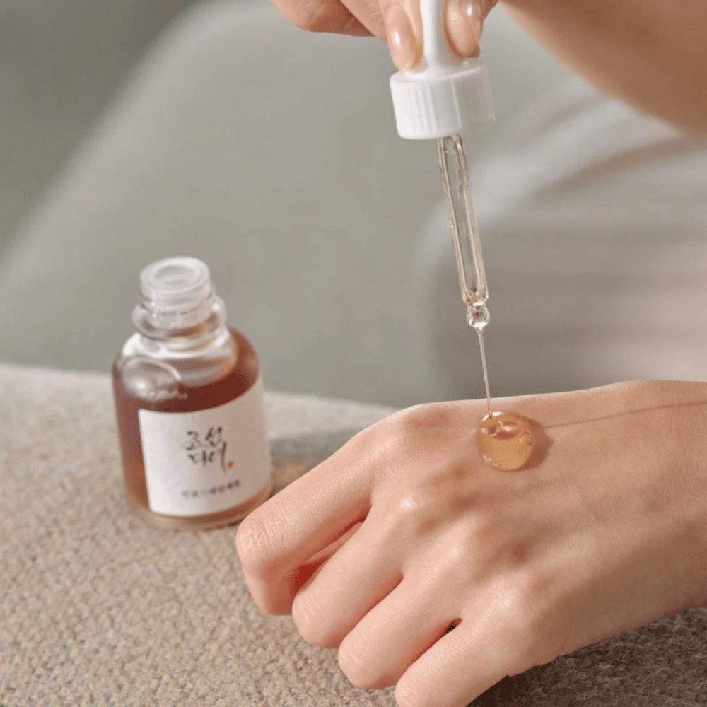 Pipet druppelt Beauty of Joseon Revive Serum Ginseng + Slakkenslijm op de huid – Koreaans serum voor elasticiteit en hydratatie.